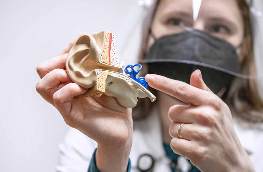 Doctor examining patient's inner ear — new tinnitus research revealing the real cause of ringing in ears